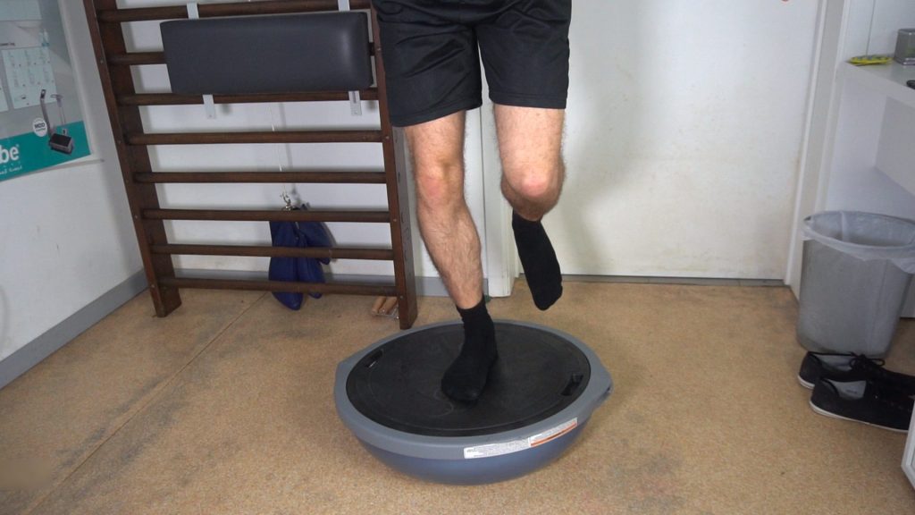 Man standing on the Bosu Pro on one leg to train balance